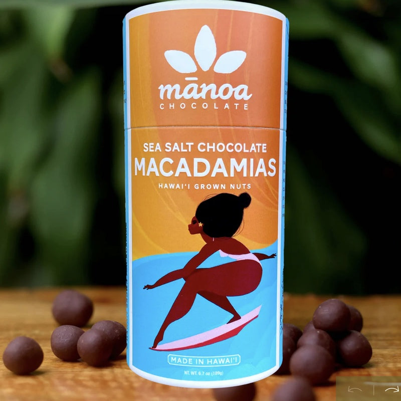 Manoa Chocolate Sea Salt Chocolate Macadamias packaging with macadamias on a wooden surface