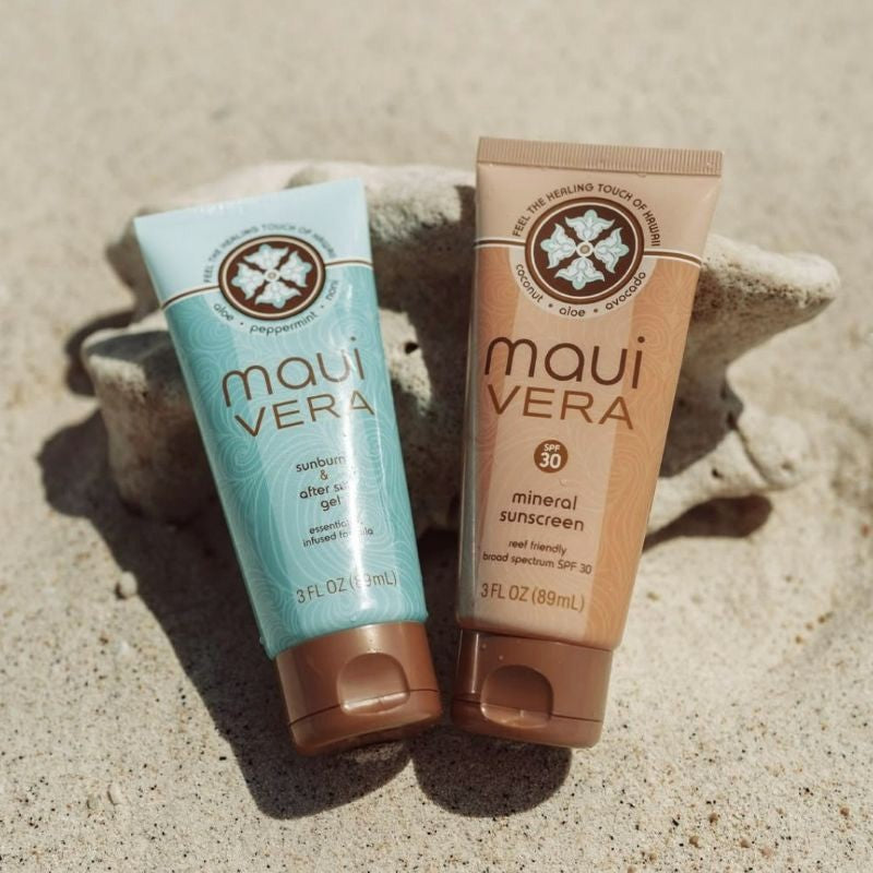 Two Maui Vera sunscreen and aftershave products on a sandy background