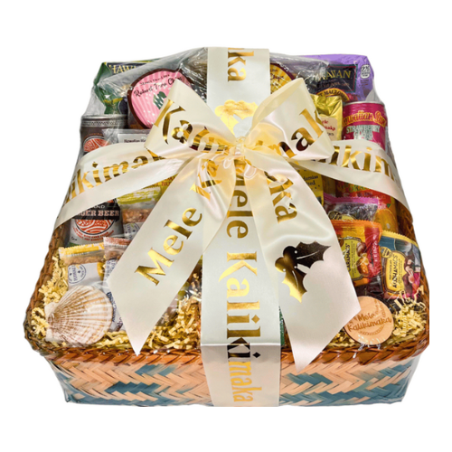 A bamboo basket filled with products created in Hawaii, including Upcountry Apiaries honey, Island Princess chocolate covered macadamia nuts, chips, etc. The gift basket is completed with an ivory bow with gold writing that says "Mele Kalikimaka"