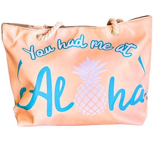 peach-toned beach bag featuring the phrase "You Had Me at Aloha" pineapple graphic on white background