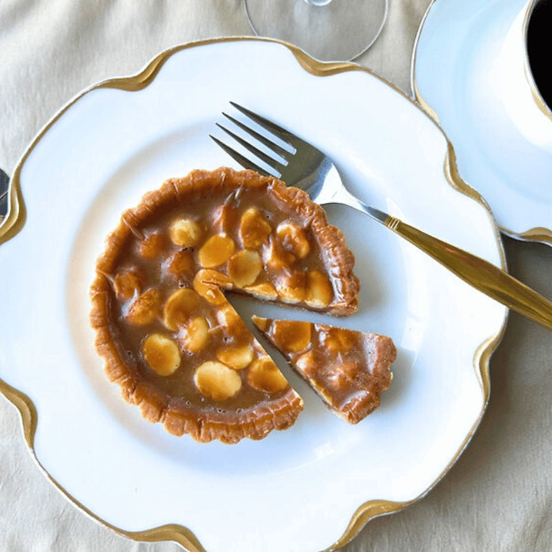 Apple pie with a slice removed on a decorative plate with gold trim.