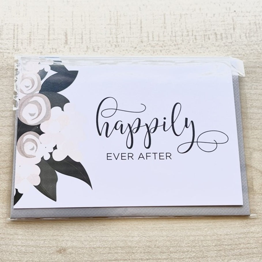 Greeting card with floral design and 'happily ever after' text on a textured surface