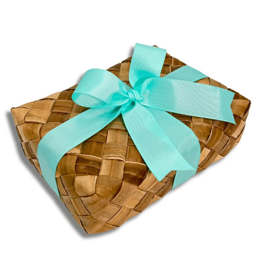 Woven basket with a turquoise ribbon on a white background