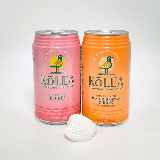 Two Kolea sparkling hop water cans, one pink and one orange, with a shell on a white background.