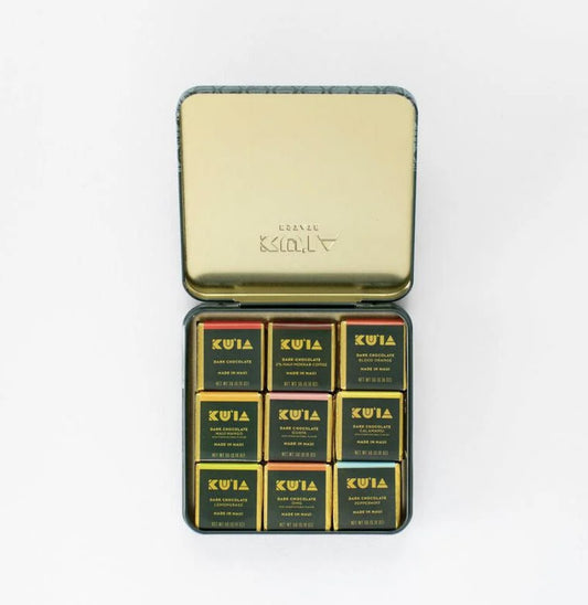 Gold tin containing KUIA chocolate bars on a white background
