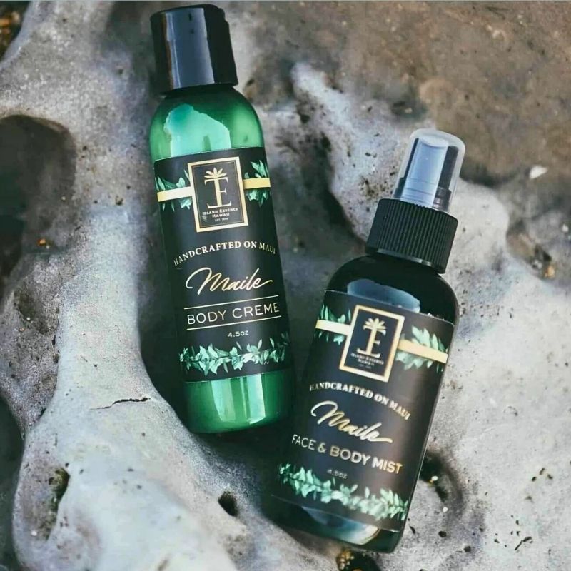 Two bottles of Maile body products on a textured surface