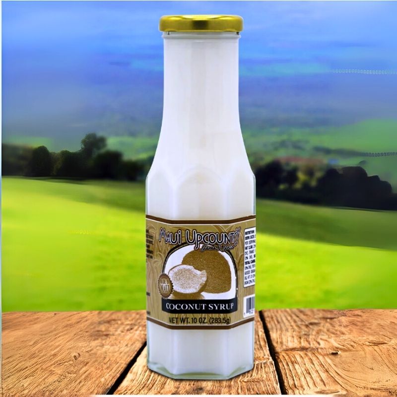 Bottle of coconut syrup with a label on a wooden surface and blurred green field background