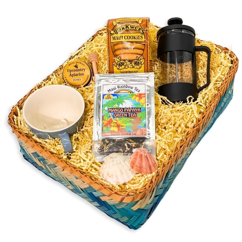 Gift basket with a mug, cookies, tea package, and French press on a white background