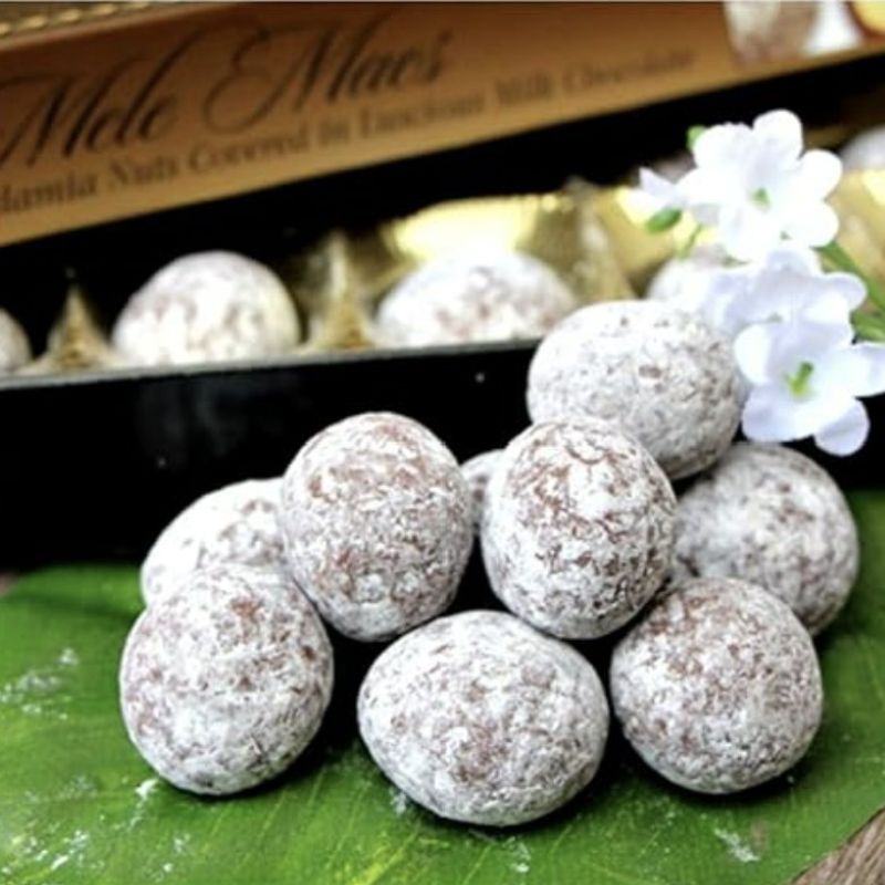 Chocolate truffles on a green leaf with a Mele & Mac's box in the background