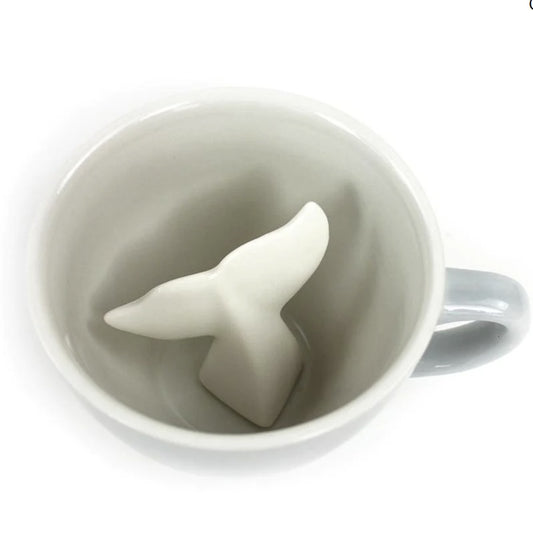 Gray mug with a white whale tail-shaped object inside on a white background